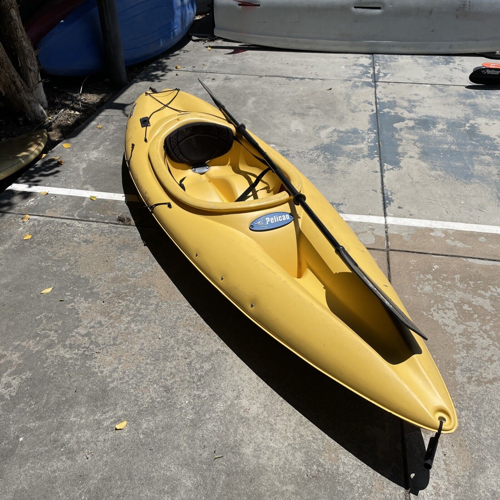 Yellow 100x pelican maxim recreational kayak in concrete background with sunlight